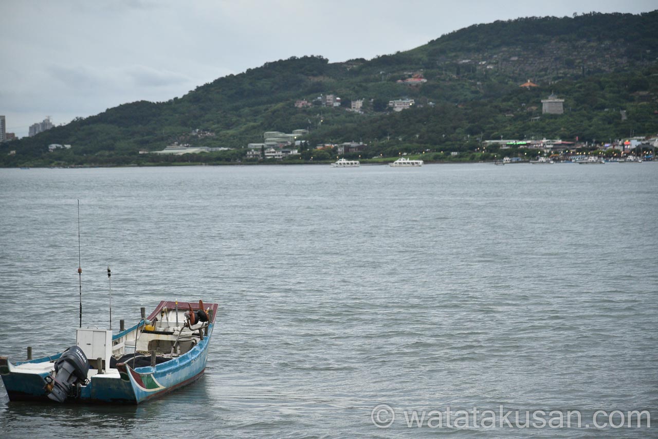 台湾の淡水河を小舟が進んでる